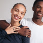 Man and woman smiling, showcasing Pilgrim's FOCUS crystal ring, gold-plated with shiny Preciosa crystals, an adjustable statement piece for a bold, glam look.