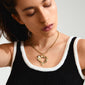 Woman wearing Pilgrim's TIDE gold-plated necklace, featuring a bold curb chain and chunky heart pendant, reflecting a unique handcrafted style.