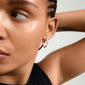 Close-up of a woman wearing Pilgrim's TIDE silver-plated hoop earrings, showcasing their modern, handcrafted design with a convenient click clasp.