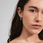 Close-up of a woman wearing Pilgrim's FEEL earrings, silver-plated square hoops with a sleek rectangular design, embodying minimalist Scandi style.