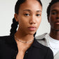 Woman with braided hair wearing Pilgrim's DAWN necklace, featuring silver-plated pendants, pearls, and semi-precious stones, epitomizing effortless summer style.