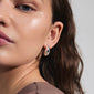 Close-up of a woman's face wearing silver-plated INTENT earrings from Pilgrim, showcasing their chunky, shiny design as a stylish and sustainable accessory.