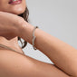 Woman wearing CONNECT crystal bracelet, gold-plated with wavy design and Preciosa crystals, showcasing trendy, eco-conscious fashion by Pilgrim.