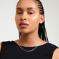 A woman with braided hair showcases the silver-plated SKY necklace by Pilgrim, adorned with Shiny Preciosa crystals for an effortlessly glamorous look.