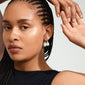 Close-up of a woman wearing Pilgrim's SKY silver-plated pearl earrings, featuring a classic design with pearlescent bead accents.