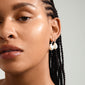 Close-up of a woman wearing Pilgrim's SKY silver-plated pearl earrings, showcasing their elegant, simple design with pearlescent glass beads and a click clasp.