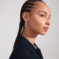 Close-up of a woman wearing Pilgrim's CHARMAINE silver-plated earrings with a nature-inspired, boho-luxe design, showcasing braided hair.