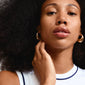 RORY gold-plated earrings on a woman with big hair, emphasizing their chunky oval shape and vintage style.