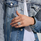 Person wearing a denim jacket, showcasing a silver LAUREL ring from Pilgrim with a unique wavy design, highlighting edgy and urban style.