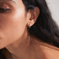 Close-up of a woman's ear wearing the LAVRA single silver-plated hoop earring with a shiny finish and click clasp.