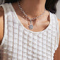 A woman wearing the CHARM horoscope pendant, silver-plated, featuring colorful Preciosa crystals, highlighting its stylish and personalized design.