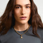 Gold-plated elephant pendant adorned with Preciosa crystals, worn by a person with long hair, showcasing Pilgrim's unique blend of style and craftsmanship.