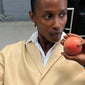 Woman holding a peach, highlighting the FREJA WEWER x PILGRIM Napoli hoops small, gold-plated earrings, showcasing their chunky silhouette and stylish design.