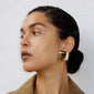 FREJA WEWER x PILGRIM Napoli earrings, gold-plated, shown on a woman with wet hair, emphasizing the chunky, puffy square design as a statement piece.