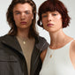 Man and woman modeling Pilgrim's VIRGO Zodiac Sign necklace, featuring a gold-plated chain with a dual-design square coin pendant.