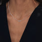 Silver-plated 'MOM' necklace on woman's neck; sleek design with cursive pendant, reflecting love and inclusivity. Perfect for layering and daily wear.