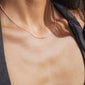 Woman wearing the SISTER silver-plated necklace featuring a cursive script pendant, designed as a sleek, genderless accessory for personal expression and daily wear.