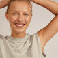 Woman smiling, showcasing Pilgrim's silver-plated WILLPOWER earrings with a wavy, organic design, adding elegance to her look.