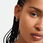 Close-up of a woman's face wearing Pilgrim's gold-plated KIRA earrings, featuring sparkling Preciosa crystals and an elegant hoop design.