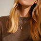 Close-up of a woman's neck wearing the CARLA pendant necklace, gold-plated with an organic pendant from Pilgrim's recycled collection, highlighting its handcrafted, natural design.