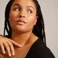 Woman wearing Pilgrim's CARLA silver-plated huggie hoop earrings, featuring an organic, handcrafted design. A close-up highlights her braided hairstyle and natural beauty.