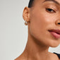 TRUST earrings gold-plated; close-up of a woman's ear showcasing elegant, handcrafted hoops from Pilgrim's collection, highlighting sustainable, fashionable design.