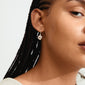 Close-up of a woman wearing Pilgrim's CALLUM silver-plated earrings with a large Preciosa crystal, showcasing their handcrafted, organic design.