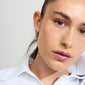 Silver-plated JORIE pearl earrings worn by a woman with brown hair in a white shirt, featuring mother-of-pearl colored glass beads for a classic style.