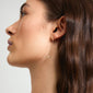 Side view of a woman wearing LYSANDRA gold-plated chain earrings with small bow pendants, showcasing their elegant, trendy design.