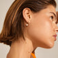 Profile of a woman wearing Pilgrim's ELINE pearl hoop earrings, gold-plated, featuring a shiny white pearl for an elegant, stylish look.