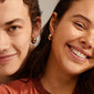 IOANNA chunky hoops gold-plated earrings, featuring a bold, shiny design, worn by a smiling couple, highlighting the earrings' stylish, elegant Nordic appeal.