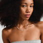 Close-up of a woman wearing the SLOAN silver-plated necklace by Pilgrim, featuring white freshwater pearls and glass beads, showcasing its elegant design.