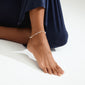 SLOAN ankle chain silver-plated with white freshwater pearls and glass beads adorns a woman's ankle, enhancing summer style with its handcrafted, romantic design.