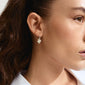 Close-up of a woman wearing Pilgrim's CHARMAINE silver-plated hoop earrings with nature-inspired flower pendants, offering a summery, stylish vibe.