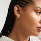 KALIA earrings silver-plated with pearl accents, worn by a woman with braided hair, showcasing a stylish and eco-friendly design from Pilgrim's Classic collection.