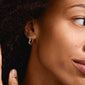 Close-up of a woman wearing HERMIONE silver-plated huggie hoops from Pilgrim, showcasing organic shapes and sparkling Preciosa crystals.