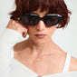 ALEXIS sunglasses in tortoise brown, worn by a woman with short red hair, showcasing a chunky, futuristic design from Pilgrim.