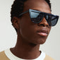 Close-up of a man wearing Pilgrim's ALESSANDRA sunglasses, showcasing the sleek, horizontal design for a fashion-forward look.