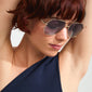 Woman with short red hair wearing ANA sunglasses grey/gold from Pilgrim, showcasing sleek Pilot-style metal frame with trendy angular shape and UV protection.